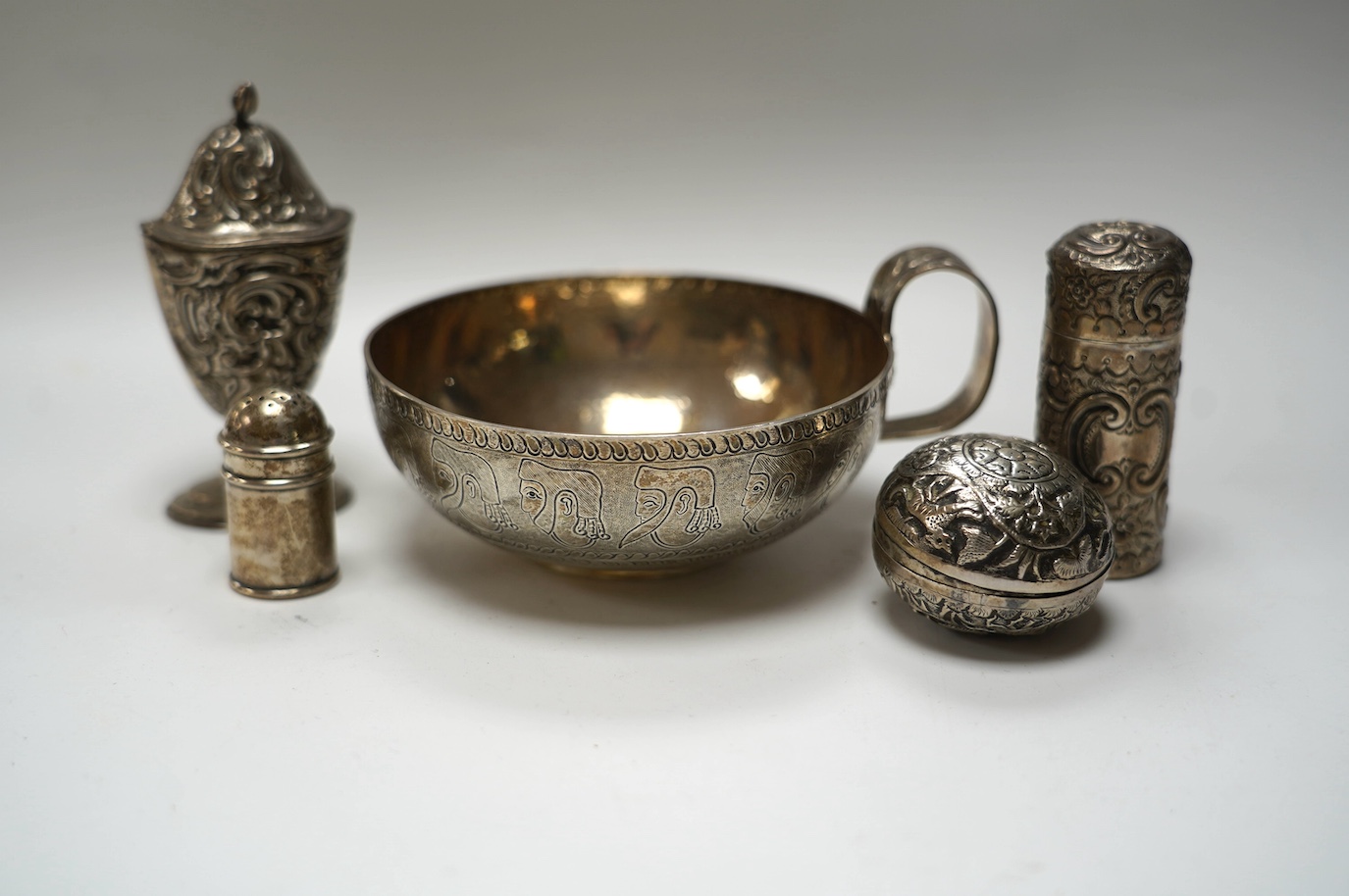 An Edwardian silver replica of a Mycenaean cup, Nathan & Hayes, Chester, 1912, height 62mm, together with a late Victorian silver mounted scent flask, two silver condiments and an Indian white metal box and cover. Condit